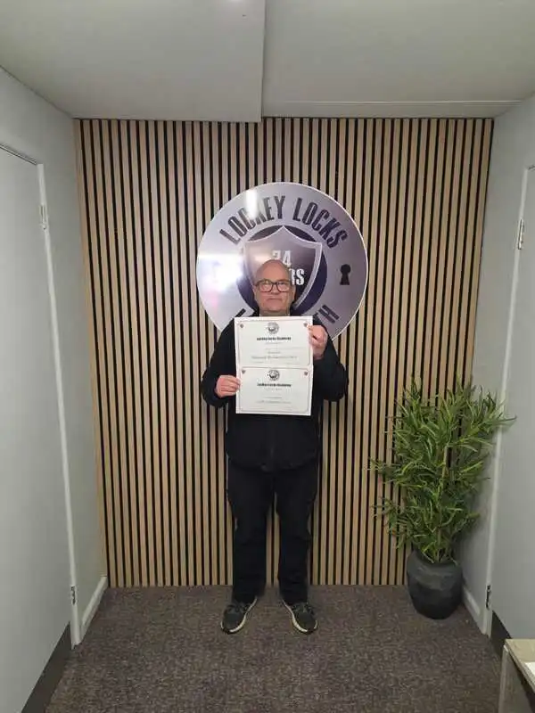 Successful locksmith training student holding certificate
