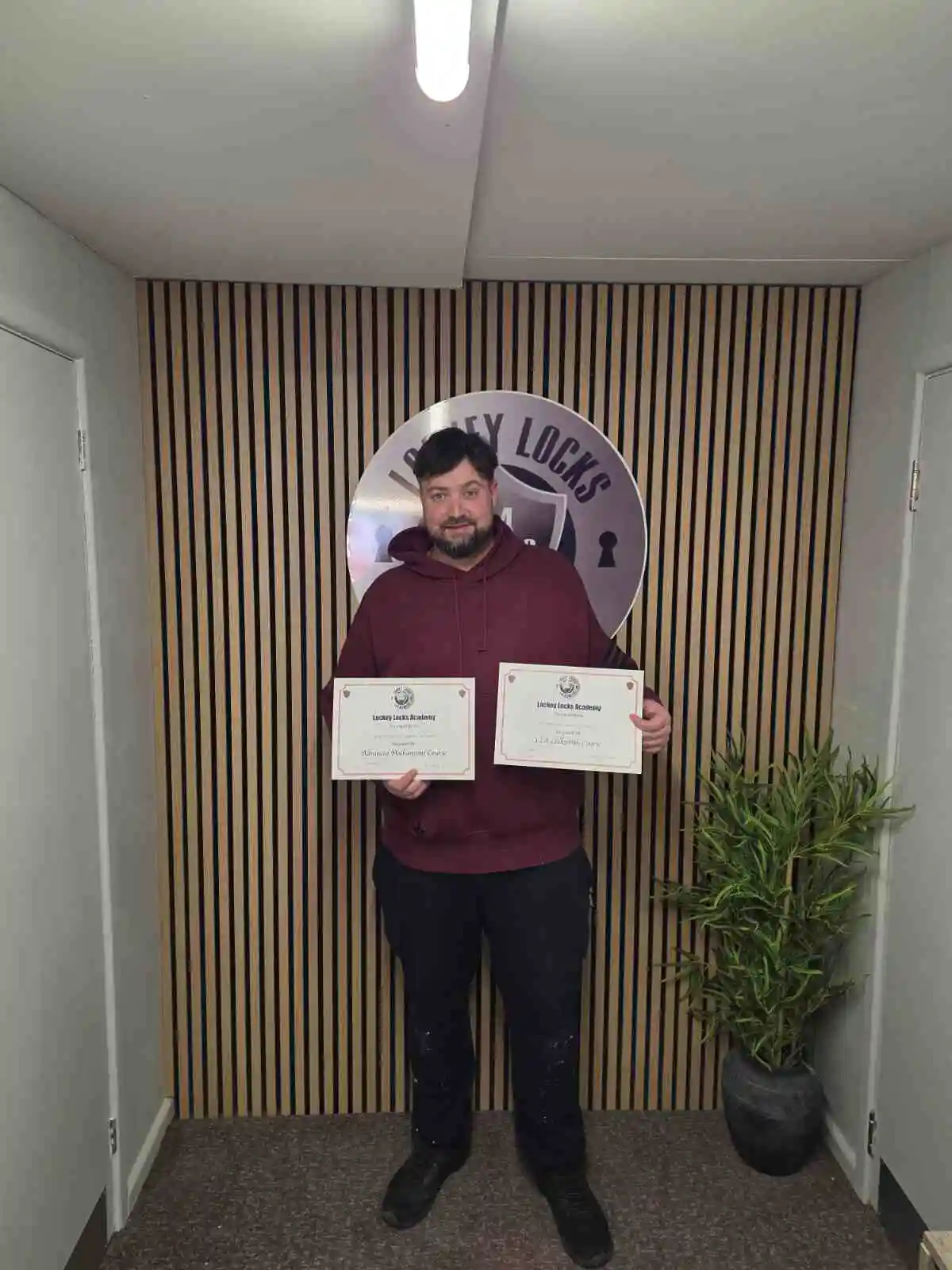 Successful locksmith training student holding certificate