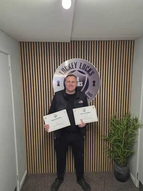 Successful locksmith training student holding certificate